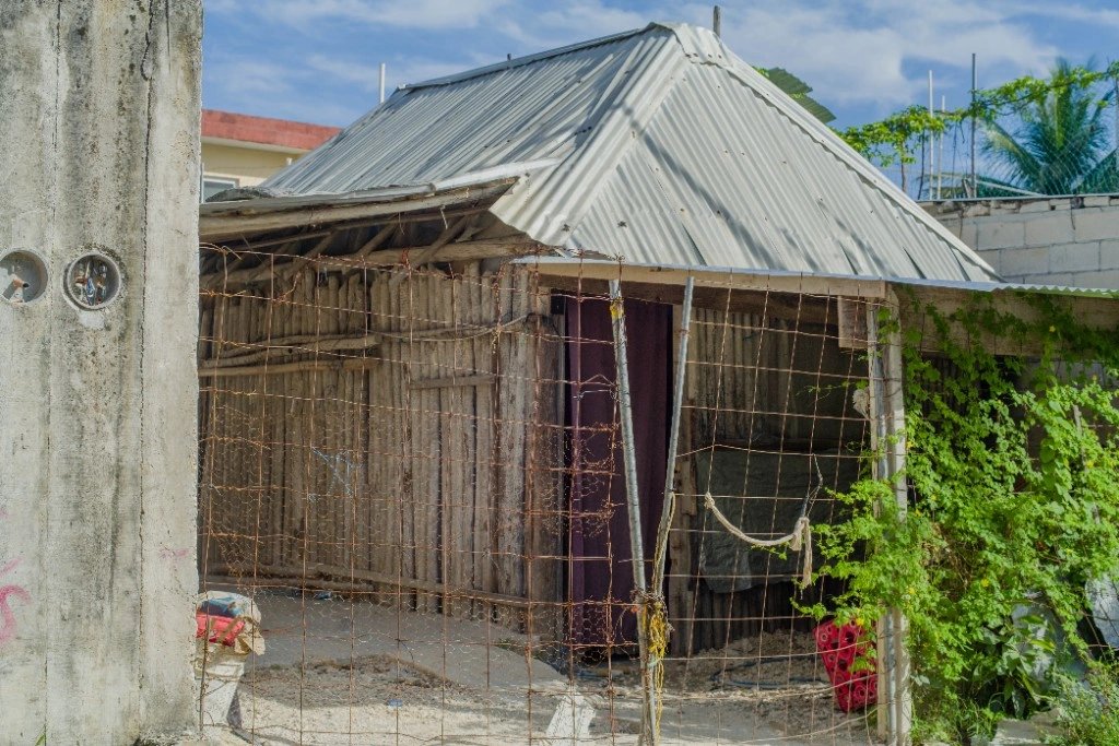 Chabola rústica con techo de lámina y valla de malla en Cancún
